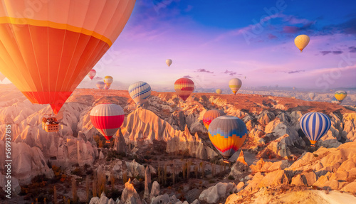 Amazing Panoramic view sunrise rocky landscape in Cappadocia with colorful hot air balloon deep canyons, valleys. Concept banner travel Turkey