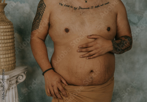 plus size Filipino man's torso with hand on belly