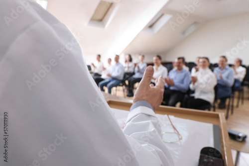 Doctor giving lecture during medical conference in meeting room, closeup