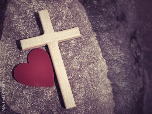 Wooden cross with red heart shaped in retro background. Christianity concept.