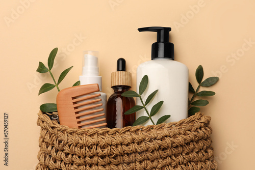 Preparation for spa. Compact toiletry bag with different cosmetic products on beige background, flat lay