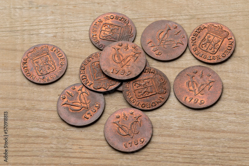 Heap of old antique Dutch VOC coins from 1789 on a wooden background
