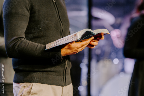 Pastor with a Bible in his hand during a sermon. The preacher delivers a speech