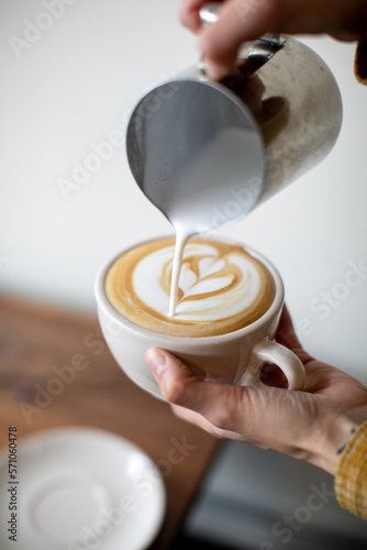 person pouring milk for latte art