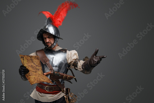 Studio shot of isolated on gray background conquistador with map.