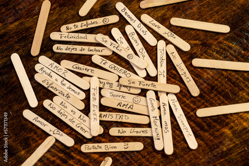 palitos de polo de madera con mensajes escritos a mano con boligrafo, condepto mensajes de la sociedad, tristeza, malos tratos, alegria, enfado, amor