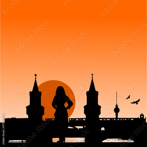 Silhouette: Frau blickt bei Sonnenuntergang auf die Oberbaumbrücke in Berlin