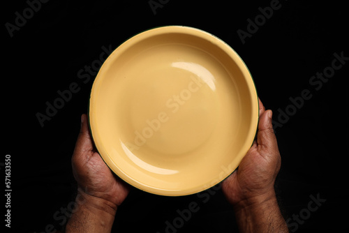 Asian dark skin top view two hand finger holding empty tin metal enamel plate dish tray on black background