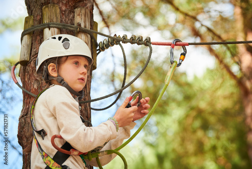 adventure rope park. Girl climbing on tree