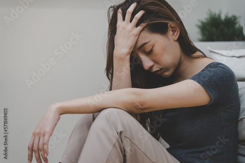 Depressed teenage sitting on the floor feeling sad.