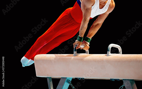 gymnast athlete exercise on pommel horse in black background