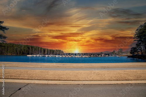 Boats and yachts docked in the marina on Lake Lanier with lush green trees and powerful clouds at sunset in Gainesville Georgia USA