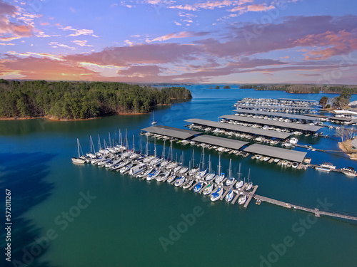 aerial shot of the boats and yachts docked in the marina on the waters of Lake Lanier surrounded by lush green trees with powerful clouds at sunset in Buford Georgia USA