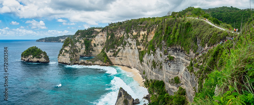 Atuh Beach is a Rustic, isolated cove beneath a sheer cliff face, with a sandy beach offshore rock formations.
