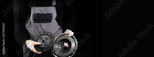 new clutch kit for a car in the hands of a car mechanic on a dark background