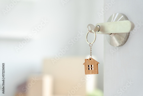 Moving house, relocation. The key was inserted into the door of the new house, inside the room was a cardboard box containing personal belongings and furniture. move in the apartment or condominium.