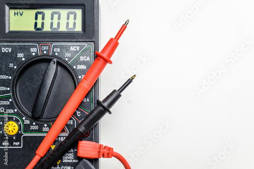 Top view of a tool for testing electrical circuits. Digital multimeter and test leads on a white background.