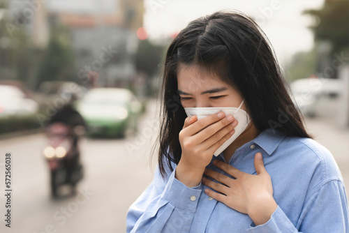 Asian woman wearing the N95 Respiratory Protection Mask against PM2.5 air pollution and headache Suffocate. City air pollution concept