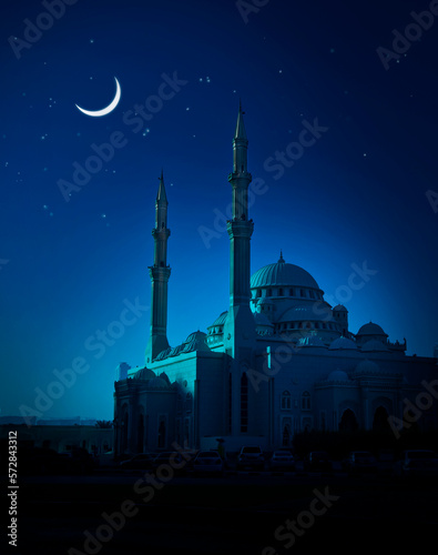 Beautiful mosque illuminated in the soothing blue moonlight. A Ramadan moon and the mosque. Photo of crescent for the occasion of Eid ul fitr.