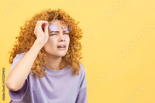 Woman taking off her glasses to see far away