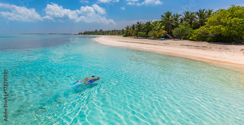 Caucasian couple of tourists snorkel in crystal turquoise water near Maldives Island. Recreational outdoor sport at luxury resort beach scene, calm sea water, couple exotic water, underwater wildlife