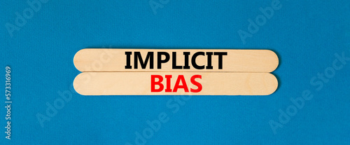 Implicit bias symbol. Concept words Implicit bias on wooden sticks. Beautiful blue table blue background. Business psychology implicit bias concept. Copy space.