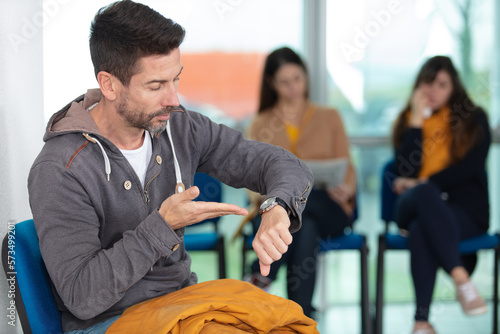 impatient man in waiting room checking his watch