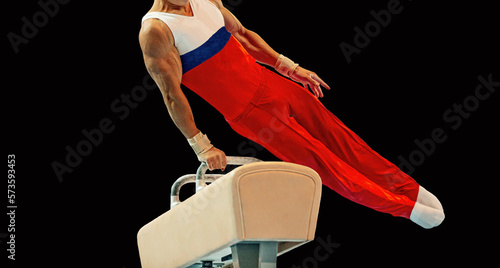 men gymnast exercise on pommel horse in black background