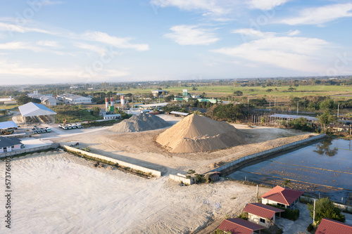 Pile of sand and rock or gravel in concrete plant with sky background in aerial view. Heap of aggregate or material from nature, mine or quarry for mix with cement, concrete for industry construction.