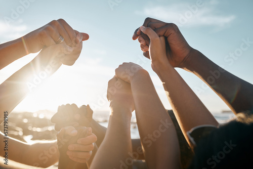 Friends, bonding and holding hands on beach social gathering, community trust support or summer holiday success. Men, women and diversity people in solidarity, team building or travel mission goals