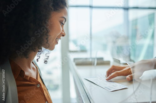 Ticket, glass window and black woman at airport or theatre with paper for travel or box office service. Customer person at cashier consultant booth counter for work booking and buying pass at seller