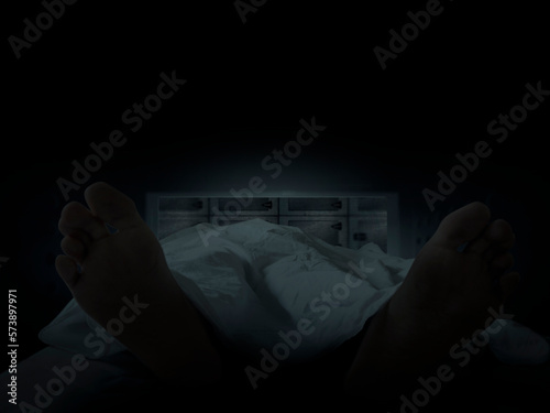 Dead body covered with sheet of cloth in morgue refrigerator view from inside