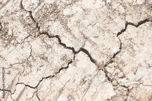 Cracked soil texture drought patterns light brown close up background