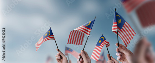 A group of people holding small flags of the Malaysia in their hands