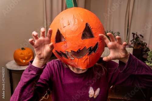 Child being silly and scary in DIY Halloween pumpkin mask