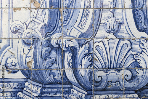Detail of vintage Portuguese ceramic tiles. Old blue azulejo facade with decorative floral ornaments. Baroque styled pattern. Antique building wall fragment. Artistic hand drawn decorative background