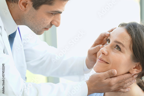 Ophthalmologist examining female patient eye in ophthalmology room.