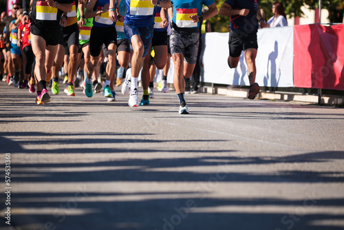 runners in start line shioes feet crowd in asphalt city running marathon