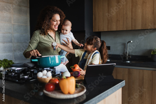 hispanic mother with children son and daughter cooking at kitchen in mexico latin america