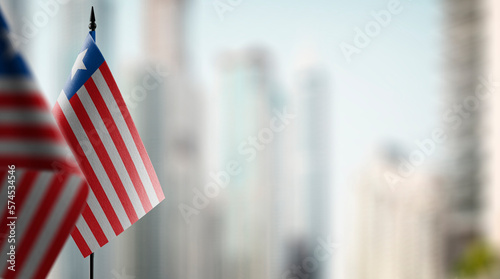 Small flags of the Liberia on an abstract blurry background