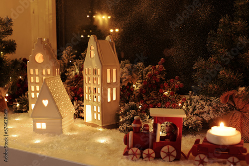 House shaped lanterns and Christmas decor on windowsill indoors