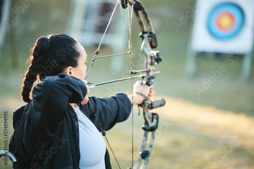 Archery woman, target and bow and arrow training for outdoor sports, athlete challenge or girl field competition. Shooting goals, talent and competitive archer focus on precision, aim or objective
