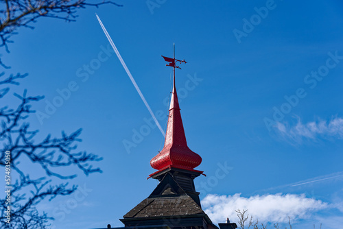 Red spire of residential house with wind vane at City of Schaffhausen on a sunny winter day. Photo taken February 16th, 2023, Schaffhausen, Switzerland.