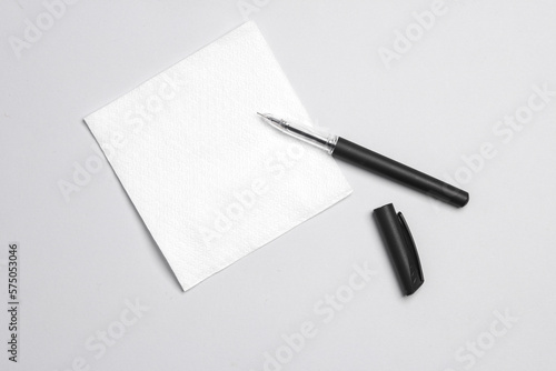White empty napkin and pen on gray background