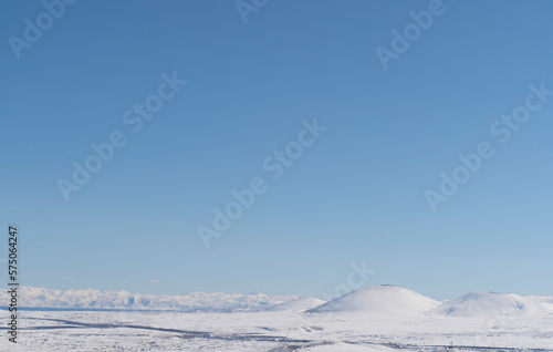 Aerial view snow covered mountains. Snowy mountain ridge on winter sunrise. Stunning mountains range covered with snow
