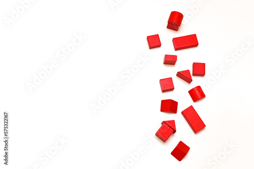 red figurines of wooden blocks of a children's educational designer are laid out on a white table. empty space