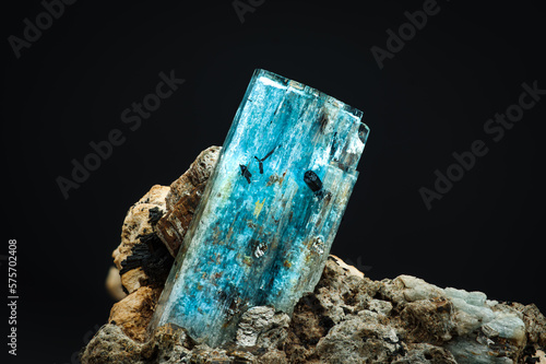 blue aquamarine with schorl (black tourmaline) inclusion. macro detail texture background. close-up raw rough unpolished semi-precious gemstone