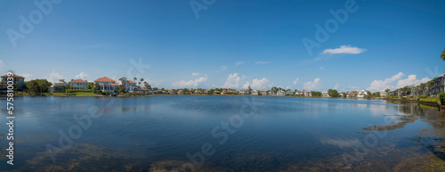 Clean reflective Four Prong Lake waterfront at Destin, Florida. Panorama of neighborhood with lakefront views and clear sky background.