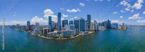High rise buildings surrounded by Miami South Channel in Miami Beach Florida. Panoramic view of the city skyline with condominiums overlooking the lagoon and blue sky.