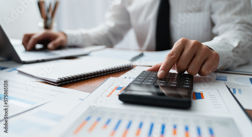 Young Asian businessmen analyze using a calculator and make comparative records of financial calculations and concepts management.